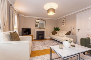 A living room with a sofa, a television, a fireplace, and a coffee table.