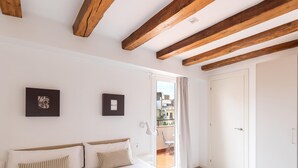 A bedroom with a bed, two pillows, a framed picture, a white door, and a view of the outside. - Penthouse Apartment with terrace (Barcelona)