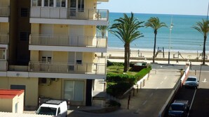 Un immeuble à plusieurs étages doté de balcons donnant sur une plage.
