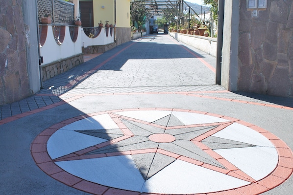 A paved pathway with a star-shaped design, leading to a building entrance.