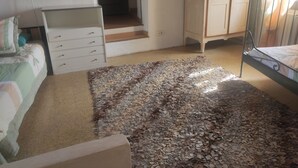 Un dormitorio con cama, cómoda, armario y alfombra.