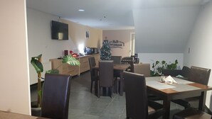 A dining area with a table, chairs, and a Christmas tree. - B&B Casa Italia (Timisoara)