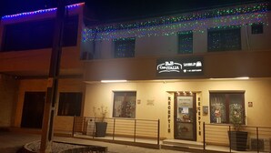 A two-story building with a sign reading "B&B Casa Italia." There are two reception doors, a small outdoor seating area with a railing, and a potted plant near the entrance. - B&B Casa Italia (Timisoara)