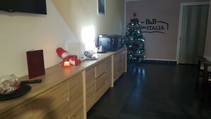 A kitchen with a wooden countertop, a coffee machine, a Christmas tree, and a wall with a sign reading "B&B ASIA ITALIA". - B&B Casa Italia (Timisoara)