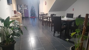 Una zona de menjador amb un arbre de Nadal, terra de rajola fosca i diverses plantes en testos.