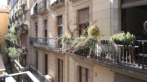 Un immeuble à plusieurs étages doté de balcons ornés de plantes et de fleurs en pot.