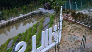 A landscaped area with a pond, a white fence, and a gazebo. - The Woodz Homestay (Tanah Rata)