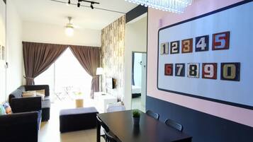 Una sala de estar moderna con comedor, que incluye una araña, una pared con azulejos numerados y un gran ventanal con cortinas.