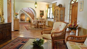 Un salon spacieux avec un escalier en bois, un coin repas et un espace salon confortable.