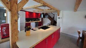 A kitchen with red cabinets, a wooden ceiling, and a built-in stove. - Beautifully designed Apartment.  Fully equipped for your holiday needs. Sleeps 7 (Interlaken)