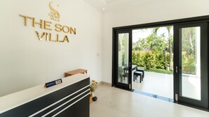 Een receptiegedeelte met een bord waarop 'The Son Villa' staat en een bord met de tekst 'Gereserveerd Visum'.
