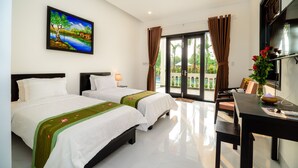 Een hotelkamer met twee bedden, een bureau, een stoel, een televisie en een schilderij aan de muur.