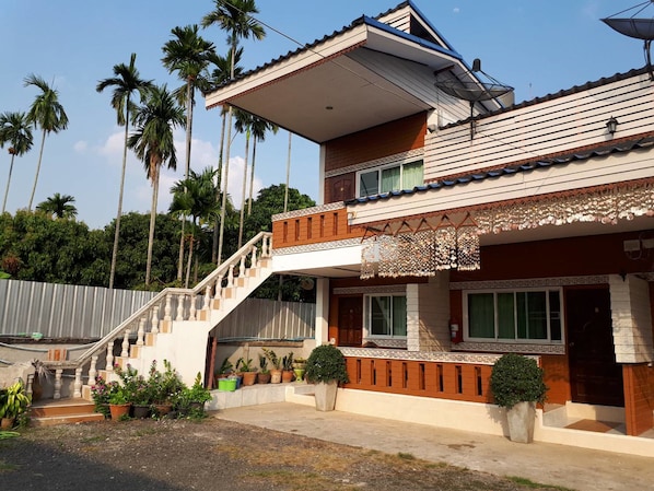 A two-story house with a balcony, a staircase, and a satellite dish.
