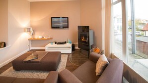 A modern living room with a fireplace, a television, and a comfortable seating area.