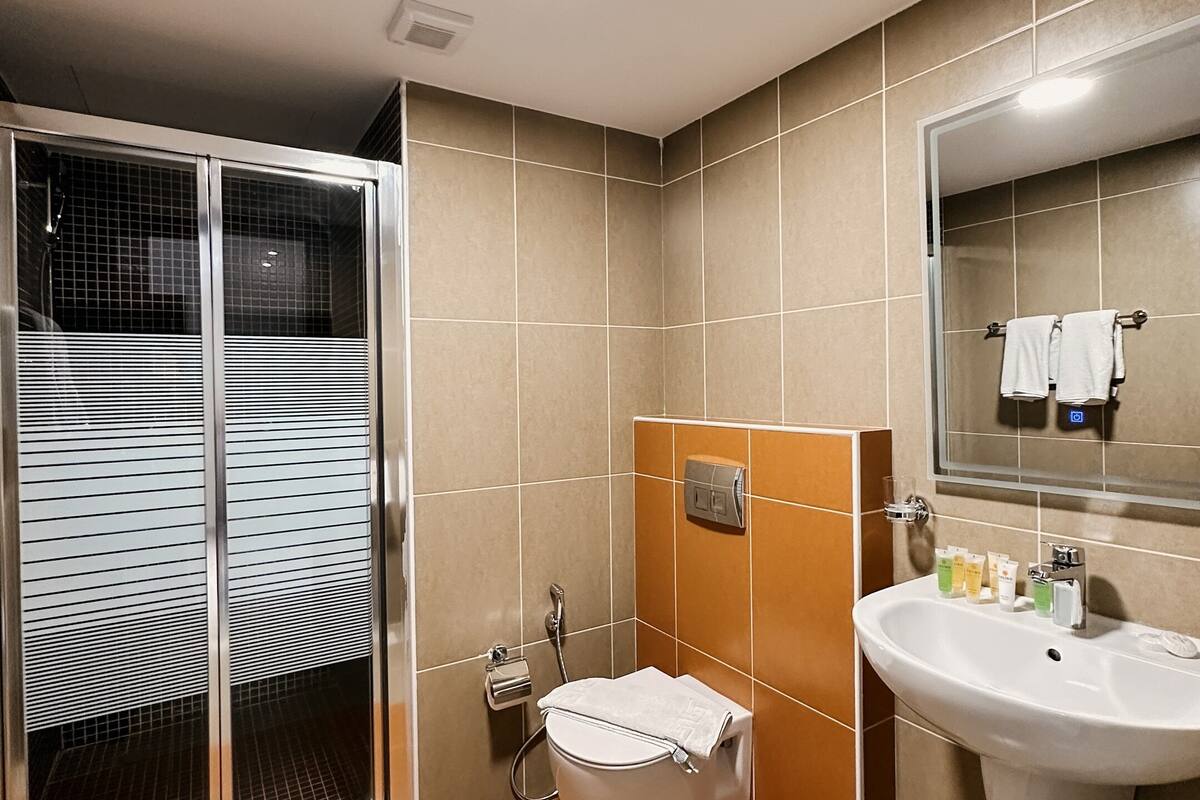 design suite, kitchen, city view | bathroom | separate bathtub and shower, slippers, towels, soap