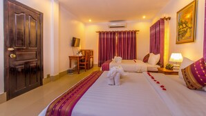 A hotel room with a large bed, a desk, a chair, and a television. - Aster Villa (Siem Reap)