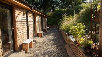 A wooden building with benches and a gravel path.