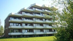 Un edificio residencial de varios pisos con balcones en cada planta.