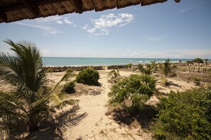 A beach view with palm trees and a clear sky. - Hilltop Cabanas (Komari)