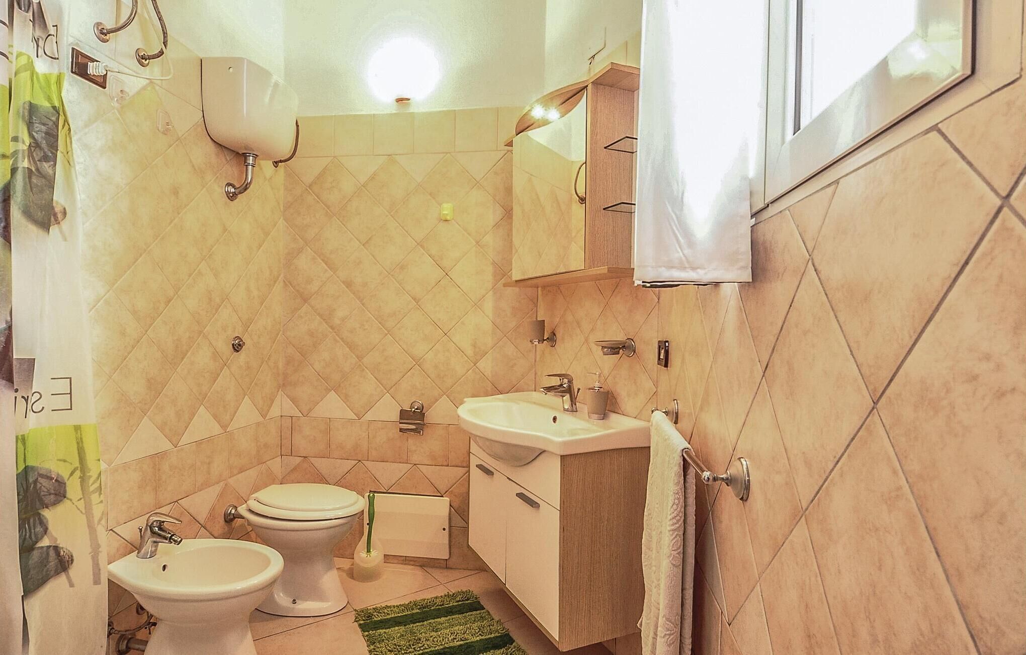 A compact bathroom with a toilet, two sinks, a mirror, and a towel rack.
