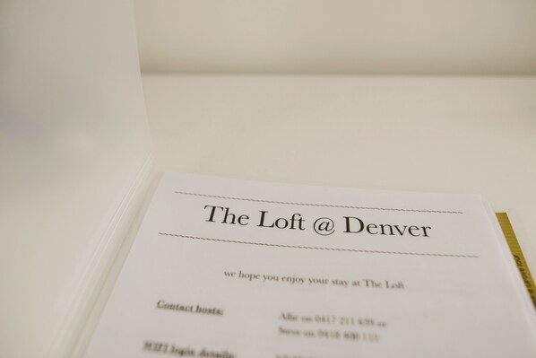 Une carte de visite d’hôtel, intitulée « The Loft @ Denver », avec les coordonnées et un message d’accueil.