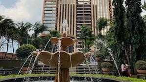 A fountain with water jets in front of a tall building with many windows. - Times Square Service Suites (Kuala Lumpur)