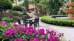 A courtyard with outdoor seating, a fountain, and lush greenery. - Times Square Service Suites (Kuala Lumpur)