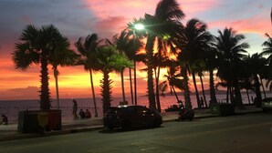 A sunset view with palm trees and a beach. - Sunlight Hotel (Pattaya)