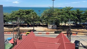 A coastal view with a beach, palm trees, and a clear sky. - Sunlight Hotel (Pattaya)