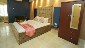 Quarto de hotel com uma cama grande, um guarda-roupa e um espelho.