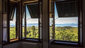 A room with large windows offering a view of a mountainous landscape. - Arxontiko Mytilineou Skretaion (South Pelion)