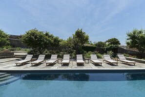 A poolside area with lounge chairs and a stone pool.