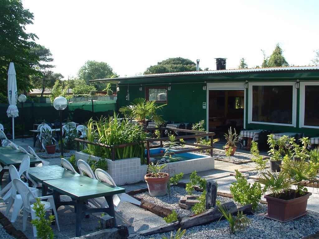 A patio area with outdoor seating, a pool, and potted plants.