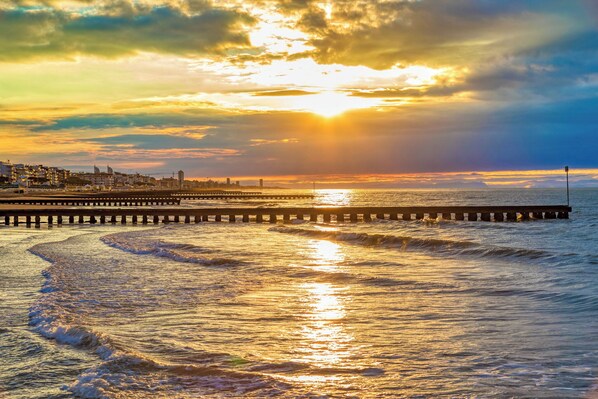 A pier extending into the water with a city skyline in the background.