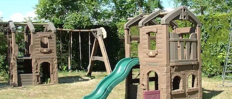 A playground with a slide and climbing structures.