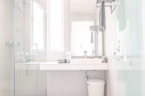 A modern bathroom with a glass shower enclosure, a white sink, and a large mirror. - La Vogue Boutique Hotel & Casino (Sihanoukville)