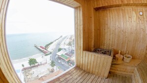 A wooden cabin with a large window overlooking a beach and road. - La Vogue Boutique Hotel & Casino (Sihanoukville)