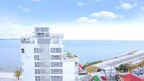 A multi-story hotel with balconies, located near a beach with a clear view of the sea. - La Vogue Boutique Hotel & Casino (Sihanoukville)