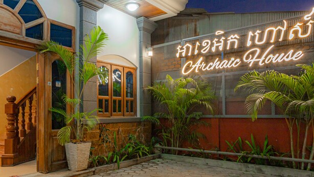 A building with a sign reading "Archic House" and a staircase leading to the entrance.