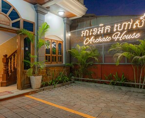A building with a sign reading "Archic House" and a staircase leading to the entrance. - Archaic House (Siem Reap)