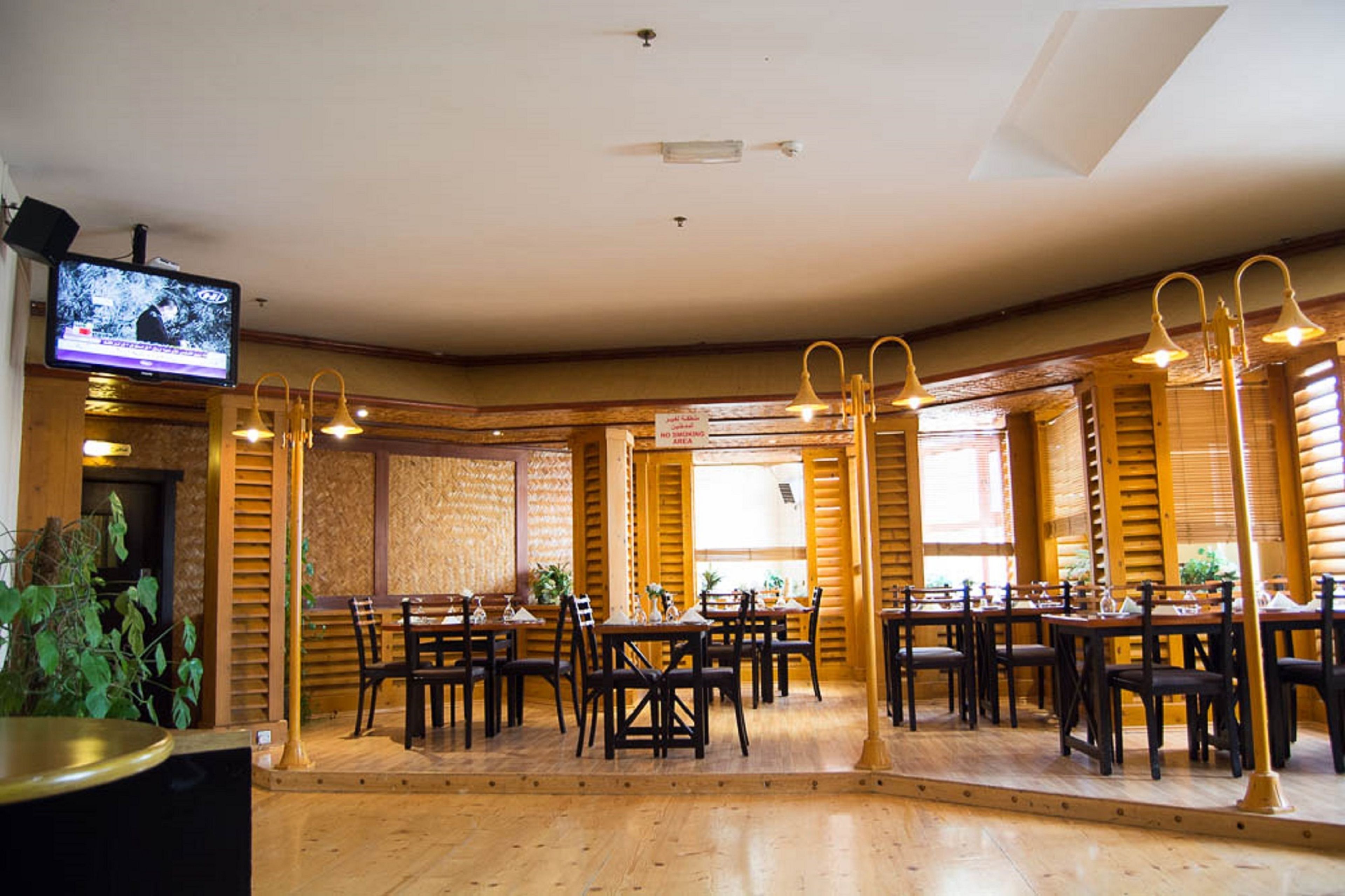 Un restaurante con interior de madera y varias mesas y sillas.