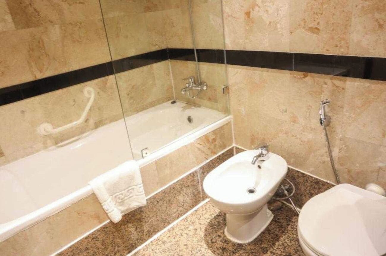 Un baño con bañera, lavamanos e inodoro.