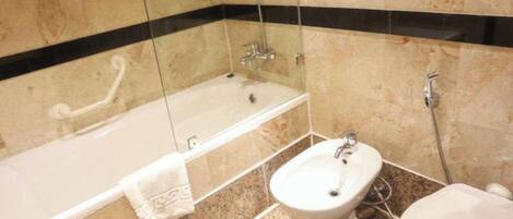 Un baño con bañera, lavamanos e inodoro.