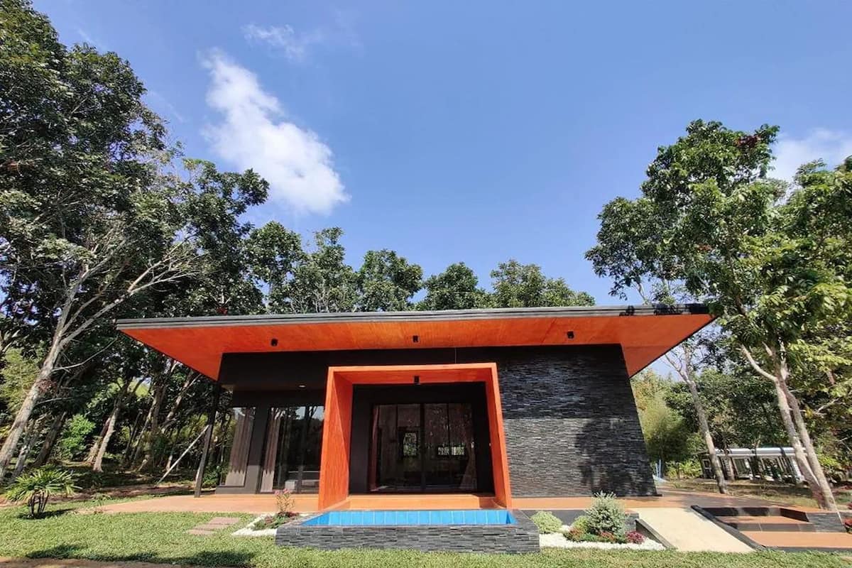 A modern building with a prominent orange roof and a stone facade.