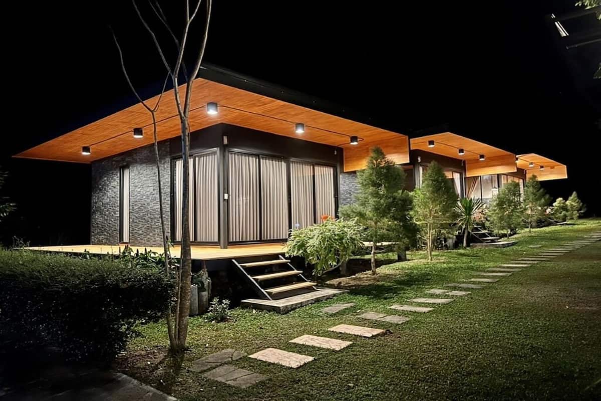 A modern, multi-story residential building with a wooden deck and large windows.