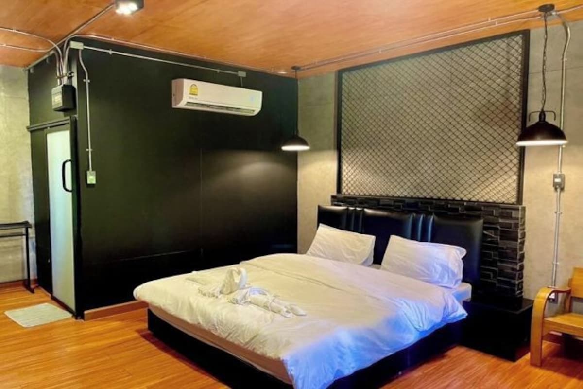 A modern bedroom with a large bed, an air conditioning unit, and a unique textured wall.