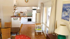 Een ruimtelijke leefruimte met een eethoek, keuken en uitzicht op zee.