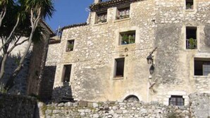 Um edifício de pedra com várias janelas e uma varanda.