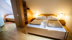 Ein ordentlich bezogenes Bett mit Handtüchern, einem Holzkopfbrett und zwei Nachttischlampen.