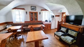 Ein gemütliches Zimmer mit Holzmöbeln, einem Fernseher und einer Küchenzeile.
